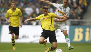 Borussia-Dortmund-s-Durm-is-challenged-by-Borussia-Moenchengladbach-s-Herrmann-during-Bundesliga-soccer-match-in-Moenchengladbach